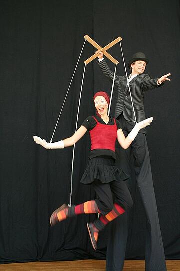 Golila - auf Hochstelzen mit Marionetten.