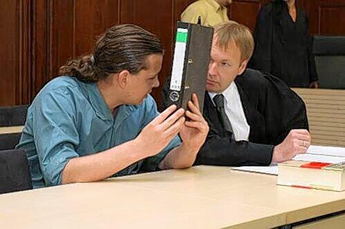 Hinter einem Aktenordner versteckte der Kinderschänder Michael Z. (hier mit Anwalt Nils Junge) vor dem Prozess sein Gesicht.