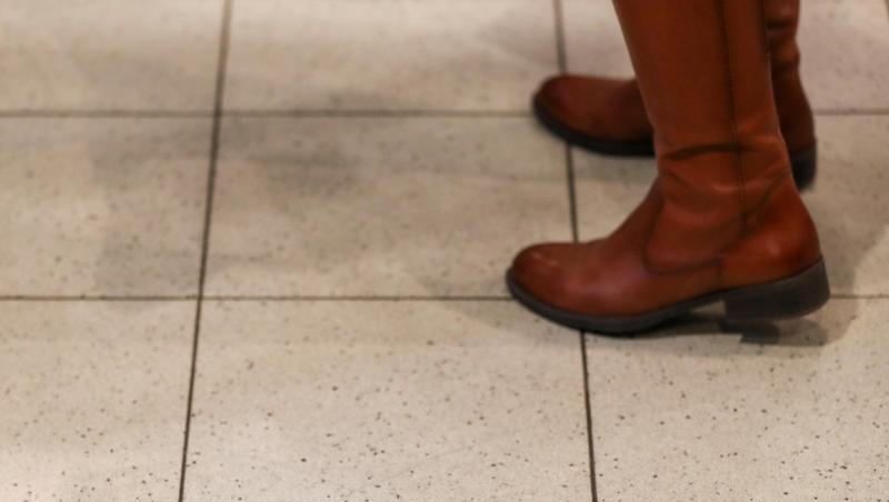 Eine Frau steht an der Kasse eines Supermarkt hinter einem Warnaufkleber, der um Abstand bitte. Eine Frau steht an der Kasse eines Supermarkt hinter einem Warnaufkleber, der um Abstand bitte.