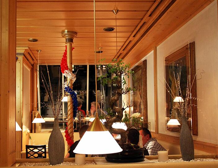 Helle Holzvertäfelung, cremefarbene Polster &ndash; so sieht das Restaurant innen aus.