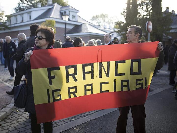 Gegner der Umbettung tragen eine spanische Flagge mit der Aufschrift "Franco Danke".