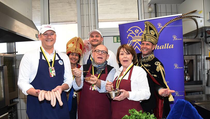 Metzgerobermeister Andy Gaßner (l.) präsentiert stolz die Narrhalla-Wurst. Begeistert mit dabei: Metzger Toni Gaßner (hinten Mitte), Schauspieler Jürgen Kirner (M.) und Gitti Walbrun. Natürlich dürfen auch die Repräsentanten der Narrhalla nicht fehlen.