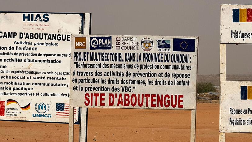 Auf dem Gelände eines Lagers für Flüchtlinge aus dem Sudan im Osten des Tschads stehen die Logos von Hilfsorganisationen, die dort im Einsatz sind. (Archivbild) Auf dem Gelände eines Lagers für Flüchtlinge aus dem Sudan im Osten des Tschads stehen die Logos von Hilfsorganisationen, die dort im Einsatz sind. (Archivbild)