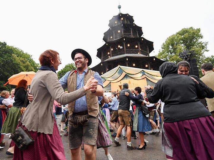 Fröhliche Gesichter beim Kocherlball am Chinesischen Turm in Münchens Englischem Garten.