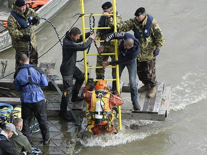 Ein Taucher geht in die Donau, um das Wrack des Ausflugsboots zu untersuchen.