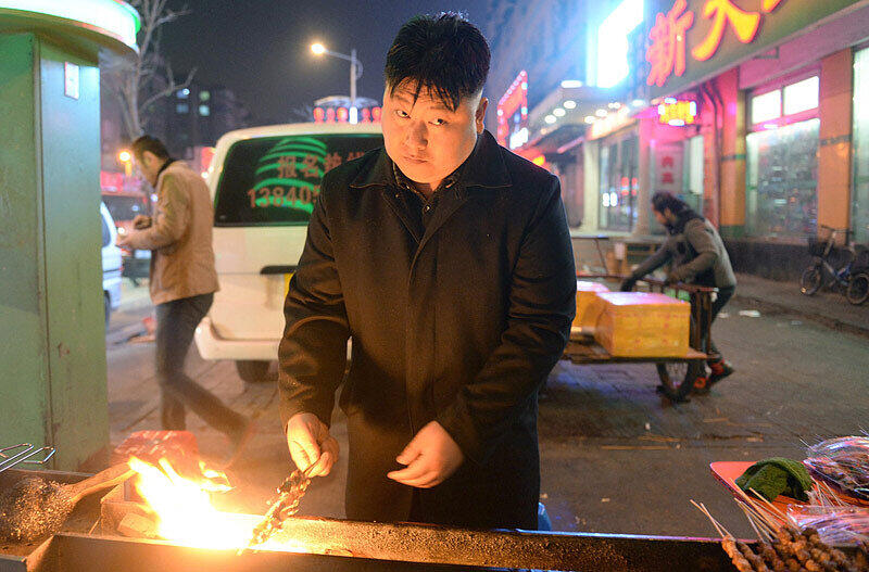 Ein Imbiss-Verkäufer verkleidet als Kim Jong Un. Der nordkoreanische Diktator erfährt bei Chinas Jugend viel Hohn und Spott.