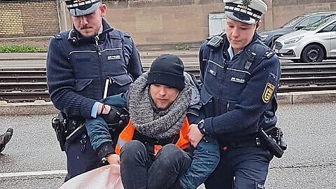 Riedacher wird von der Polizei weggetragen.