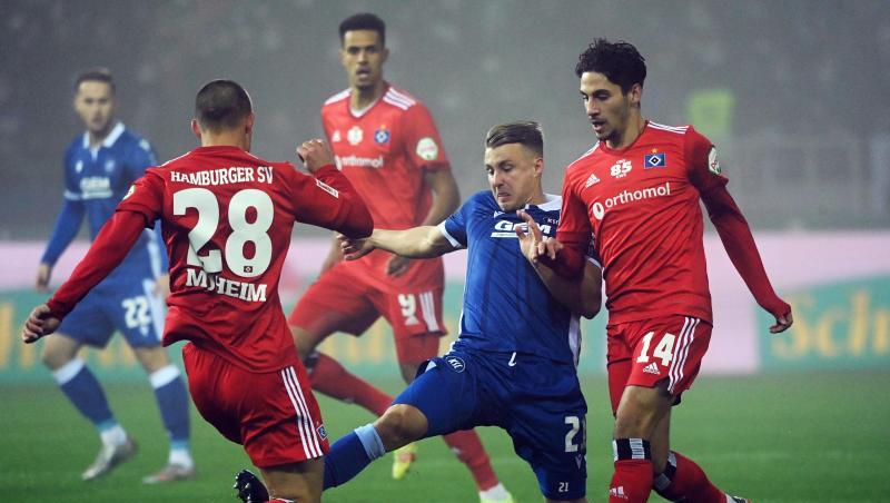 Der Karlsruher Marco Thiede (M) kämpft mit den Hamburgern Miro Muheim (l) und Ludovit Reis um den Ball.