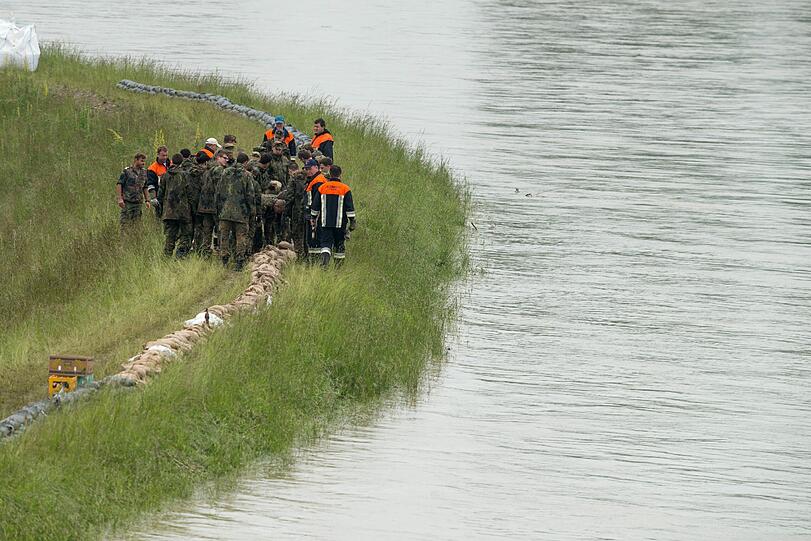 Einsatzkräfte der Feuerwehr und Bundeswehr sichern Dienstag nahe Winzer bei Deggendorf (Bayern) einen Donaudamm vor dem Hochwasser.