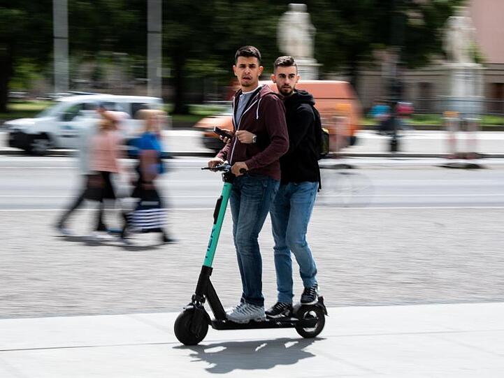 Auch das ist verboten: Touristen fahren zu zweit auf einem E-Roller durch Berlin-Mitte.