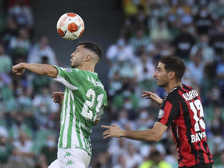 Sevillas Guido Rodriguez (l) ist vor Lucas Alario am Ball.