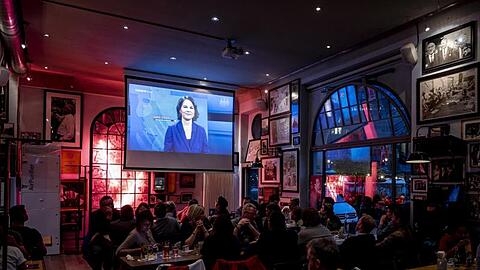 Besucher einer Berliner Kneipe schauen sich das TV-Triell an.