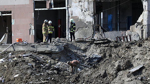 Rettungskräfte beseitigen Trümmer nach einem russischen Raketeneinschlag in einer Autowerkstatt. Russland hat den Beschuss der Großstadt Lwiw (früher: Lemberg) im Westen der Ukraine mit Raketen bestätigt.