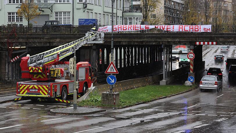 Mit Hilfe eines Drehleiterfahrzeugs entfernen Feuerwehrleute das Transparent.