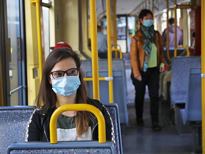 Fahrgäste einer Kölner Stadtbahn tragen Schutzmasken.