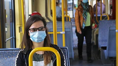 Fahrgäste einer Kölner Stadtbahn tragen Schutzmasken.