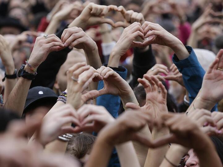 Demonstranten formen Herzen mit ihren Händen während eines Protests gegen Rassismus in Mailand.