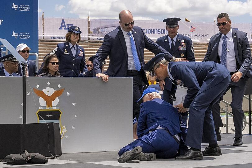 US-Präsident Joe Biden stolpert im Juni 2023 nach einer Rede in Colorado Springs auf einer Bühne über einen Sandsack.