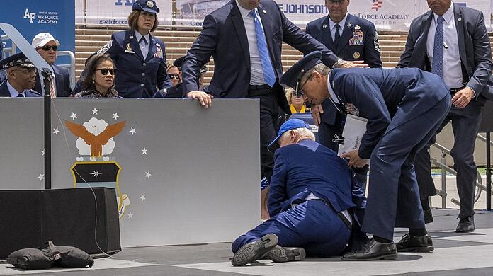 US-Präsident Joe Biden stolpert im Juni 2023 nach einer Rede in Colorado Springs auf einer Bühne über einen Sandsack.
