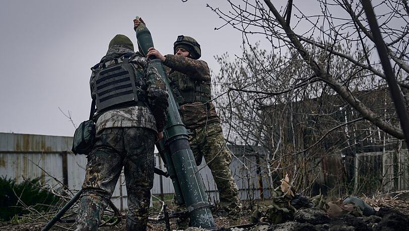 Ukrainische Soldaten feuern einen Mörser auf russische Stellungen an der Frontlinie bei Bachmut ab.
