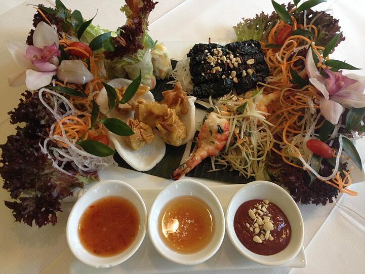 Vorspeisenplatte für zwei Personen mit Sommerrollen und grüner Papaya Salat mit Garnelen, Rindfleisch in Wildbetelblättern und knusprige Wan-Tan-Teigasche, gefüllt.