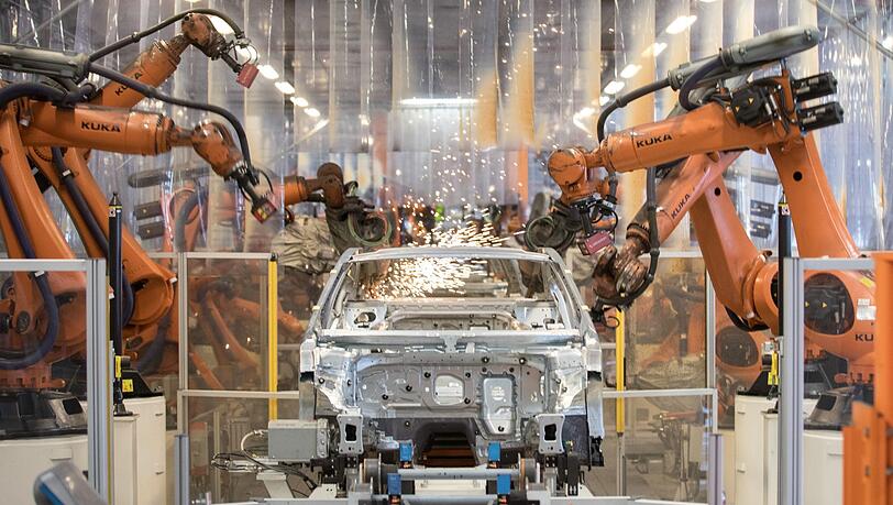 Teile eines VW Passat werden im Karosseriewerk von VW von Kuka-Robotern zusammengefügt.
