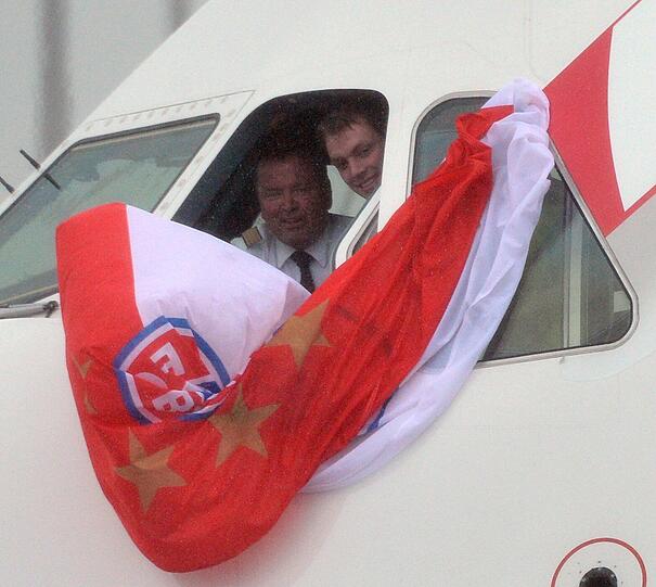 Zwei Männer halten eine Bayer-Flagge aus dem Cockpit.