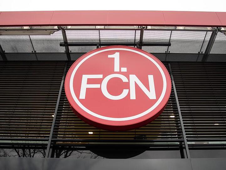 Das Logo des 1. FC Nürnberg hängt über dem Eingang der Geschäftsstelle des Vereins. Foto: Daniel Karman/Archivbild