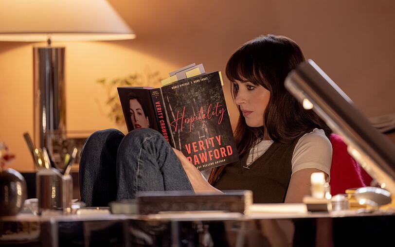 Lowen (Dakota Johnson) liest einen der Bestseller von Verity Crawford - die Frau, deren letzten Roman sie vollenden soll. Lowen (Dakota Johnson) liest einen der Bestseller von Verity Crawford - die Frau, deren letzten Roman sie vollenden soll.