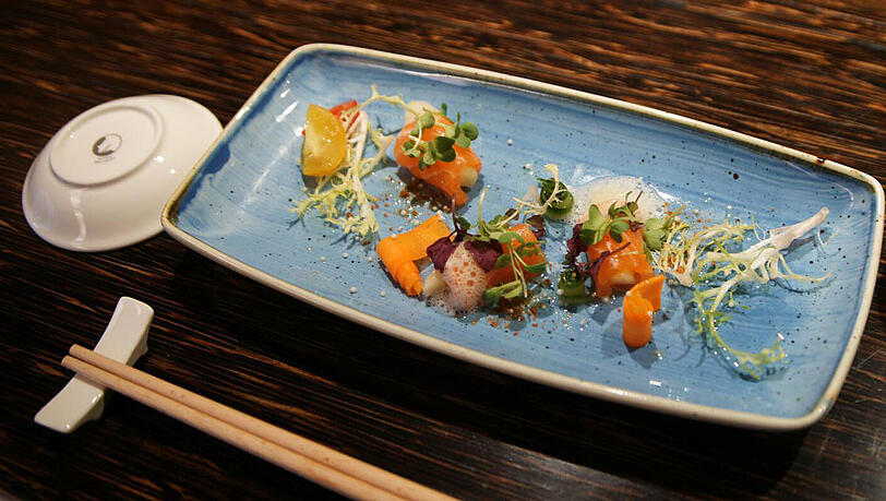 1. Gang: Wildlachs-Sashimi mit grünem Apfel, getrockneter Sojabohne und Yuzu-Trüffel-Sauce Hauchdünne Köstlichkeiten, ein wunderbarer Auftakt zum Menü – die feinen Aromen kann der leichte Vinho Verde „Falco da Raza“ vom portugiesischen Weingut Quinta da Raza mit etwas Apfel und seinem Süß-Säure-Spiel unterstützen. 1. Gang: Wildlachs-Sashimi mit grünem Apfel, getrockneter Sojabohne und Yuzu-Trüffel-Sauce Hauchdünne Köstlichkeiten, ein wunderbarer Auftakt zum Menü – die feinen Aromen kann der leichte Vinho Verde „Falco da Raza“ vom portugiesischen Weingut Quinta da Raza mit etwas Apfel und seinem Süß-Säure-Spiel unterstützen.