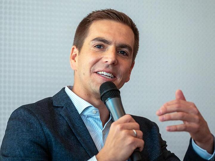 Philipp Lahm spricht mit einem Mikrofon in der Hand. Foto: Armin Weigel/dpa