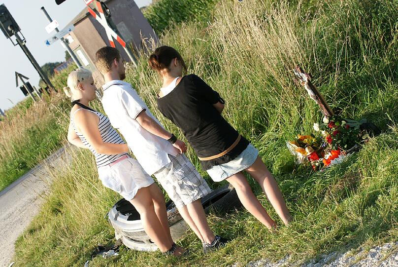 Freunde und Verwandte trauern am Bahnübergang um die beiden am Samstag verunglückten Freunde Basti und Mark.