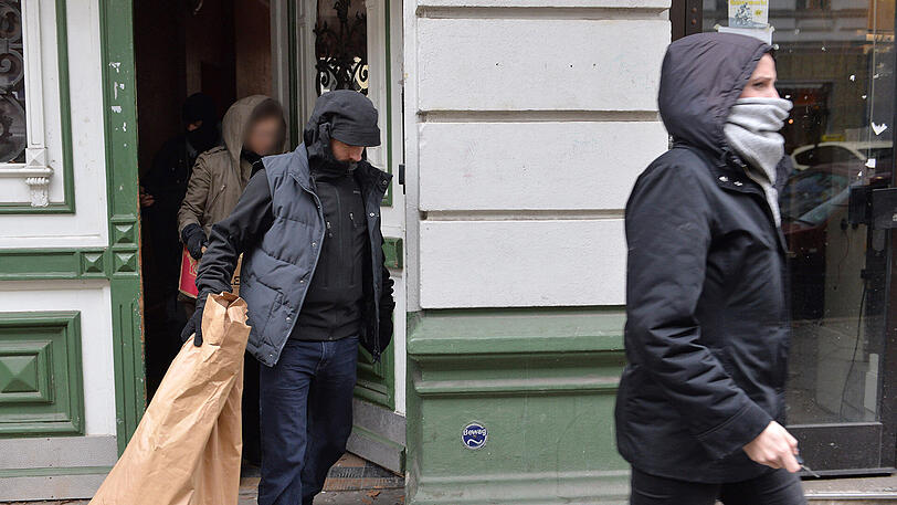 Polizeibeamte tragen am Mittwochvormittag sichergestellte Dinge in Kartons und Papiersäcken aus einem Haus in der Wittstocker Straße in Berlin Moabit
