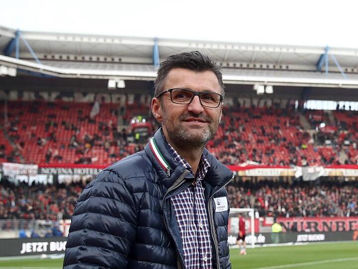 Der Nürnberger Trainer Michael Köllner geht vor Spielbeginn über den Platz. Foto: Daniel Karmann/Archiv