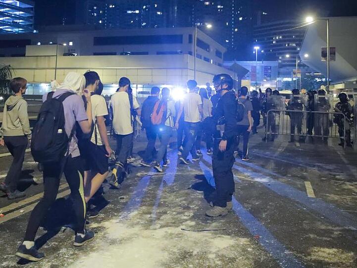 Demonstranten stellen sich der Polizei außerhalb des Campus.