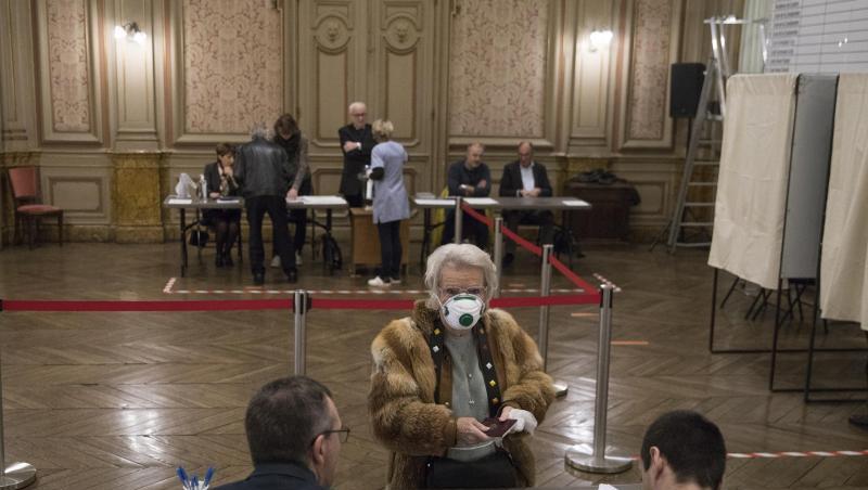 Eine Wählerin mit Atemschutzmaske registriert sich in einem Wahllokal in der französisch-italienischen Grenzstadt Menton. Eine Wählerin mit Atemschutzmaske registriert sich in einem Wahllokal in der französisch-italienischen Grenzstadt Menton.