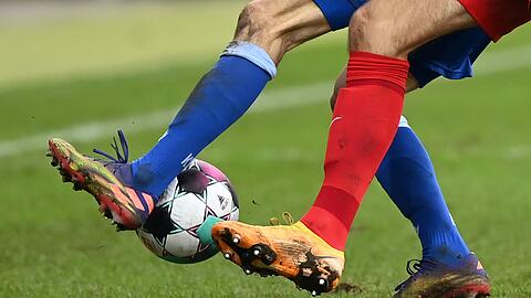 Zwei Fußballspieler kämpfen um den Ball.