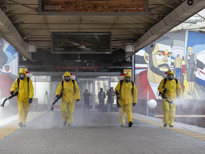 Städtische Angestellte desinfizieren einen Bahnhof in Moskau.