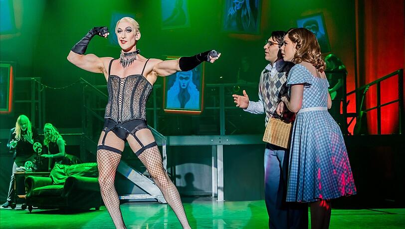 Der schrille Frank'n'Furter (Oliver Savile) schüchtert Janet (Claire Keenan) und Brad (Sev Keoshgerian) ein.