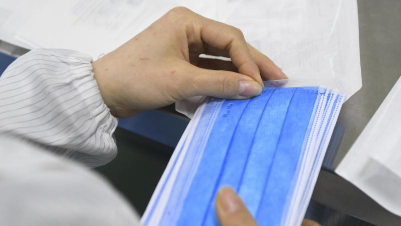 Ein Mitarbeiter eines Herstellers medizinischer Geräte verpackt Mundschutz-Masken. Ein Mitarbeiter eines Herstellers medizinischer Geräte verpackt Mundschutz-Masken.