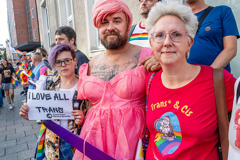 Queere Demo mit Menschenkette nach Hass-Vandalismus gegen trans Menschen: Ein violettes Band verbindet die Menschenkette