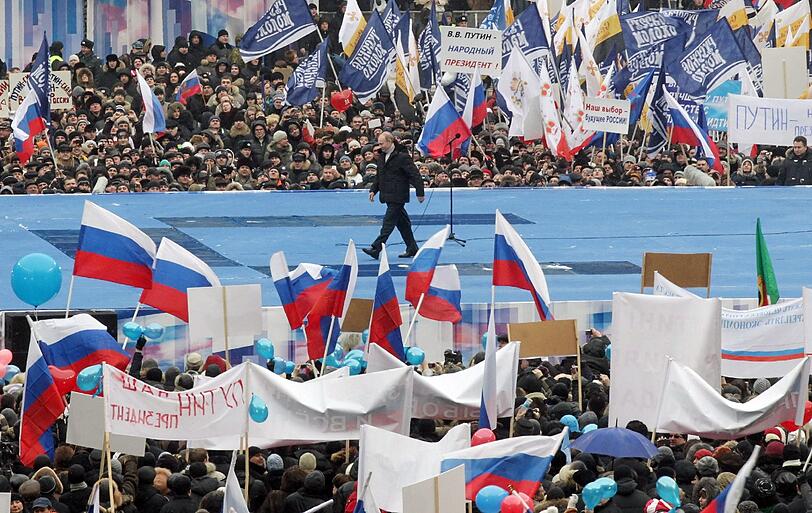 Zehntausende demonstrieren in Moskau für Putin: Bei den Wahlen am 4. März will er sich für eine dritte Amtszeit zum Präsidenten wählen lassen. Zwar bestehen kaum Zweifel an seinem Wahlsieg, doch erstmals seit seinem Aufstieg an die Staatsspitze im Jahr 2000 sieht er sich seit einigen Monaten mit einer breiten Oppositionsbewegung konfrontiert.