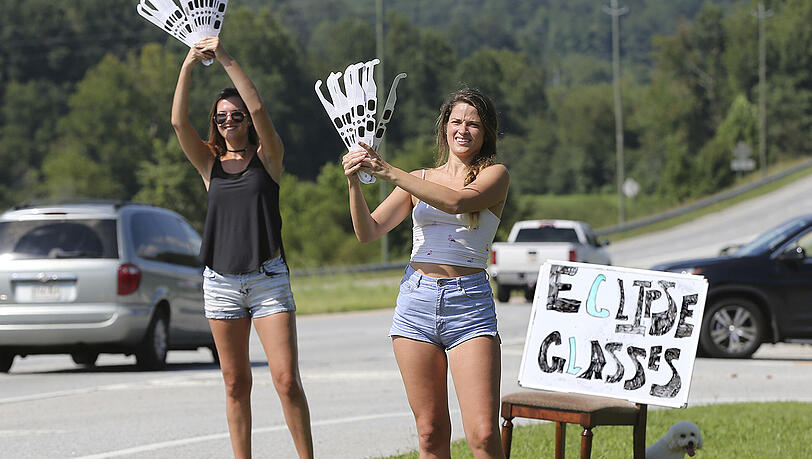 In Clayton verkaufen junge Frauen Sonnenfinsternis-Brillen: In den USA warten Millionen Menschen auf eine totale Sonnenfinsternis. In Clayton verkaufen junge Frauen Sonnenfinsternis-Brillen: In den USA warten Millionen Menschen auf eine totale Sonnenfinsternis.