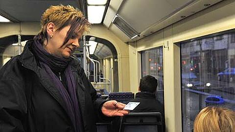 "Ihren Fahrschein bitte!&ldquo; Diese Kontrolleurin schaut sich das Ticket ganz genau an.