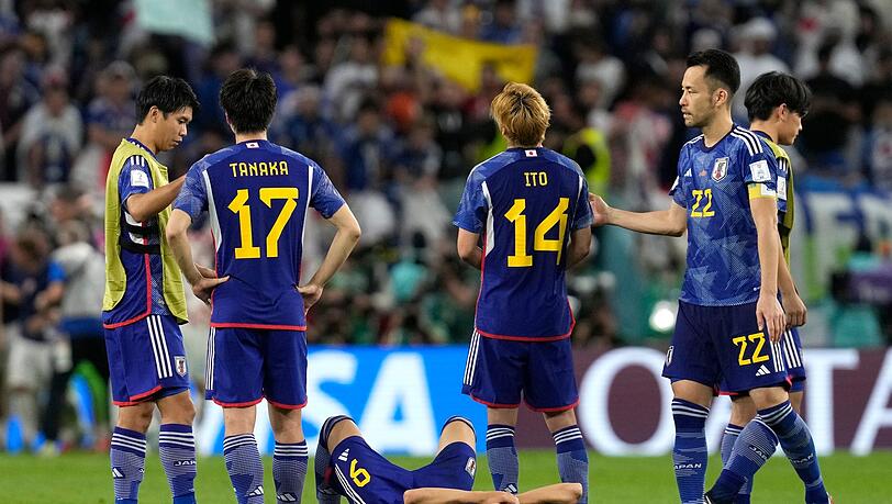 Japans Spieler stehen nach dem entscheidenden Elfmeter auf dem Platz.