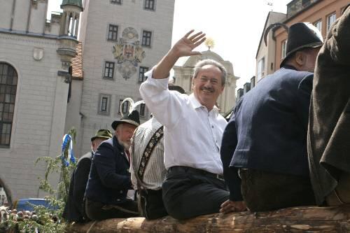 Ein winkender OB Ude mit Heiligenschein? Hinter seinem Haupt erhebt sich der Fassadenschmuck der Heilig-Geist-Kirche.
