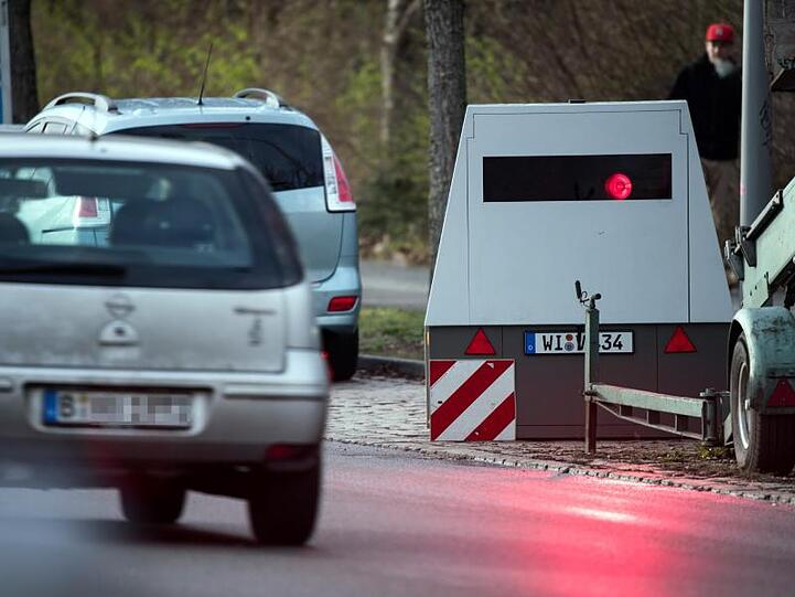 Ein Auto fährt an einem mobilen Blitzwagen, einem Geschwindigkeitsmessanhänger der Marke Votronic, vorbei.