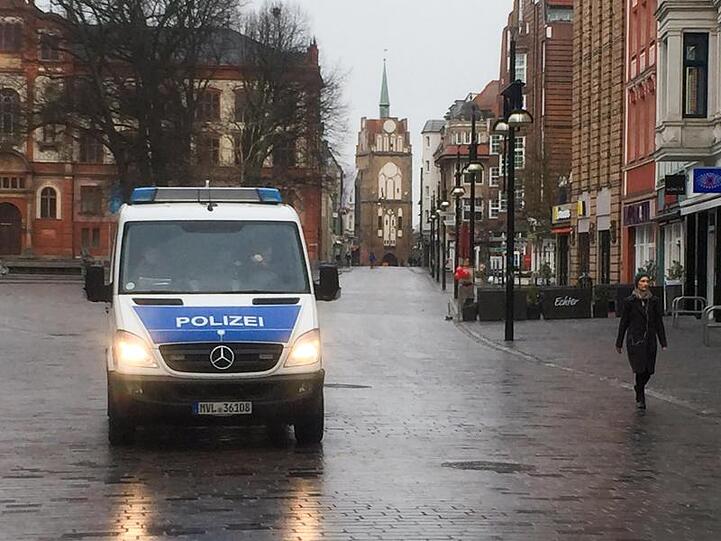 Ein Polizeifahrzeug ist in der menschenleeren Kröpeliner Straße zu sehen.