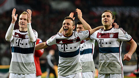 Sebastian Rode, Rafinha und Mario Götze feiern den 5:3-Sieg im Elfmeterschießen gegen Bayer 04 Leverkusen.