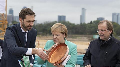 Bundeskanzlerin Agela Merkel (M) packt bei der Grundsteinlegung zur DFB-Akademie mit an.